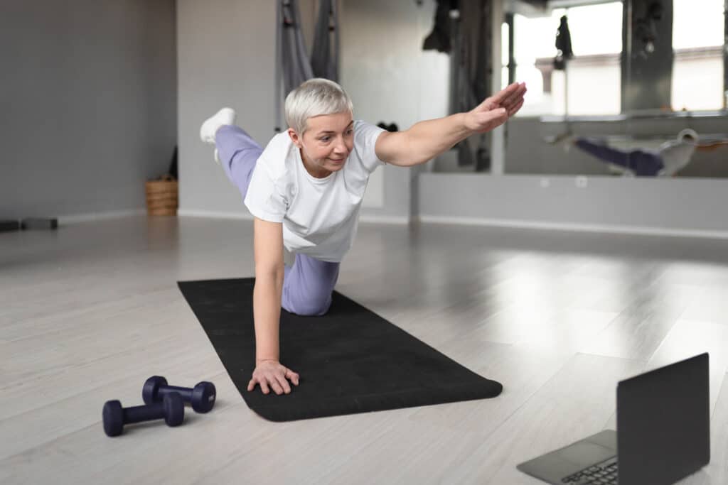 elderly-woman-doing-yoga-yoga-mat-gym
