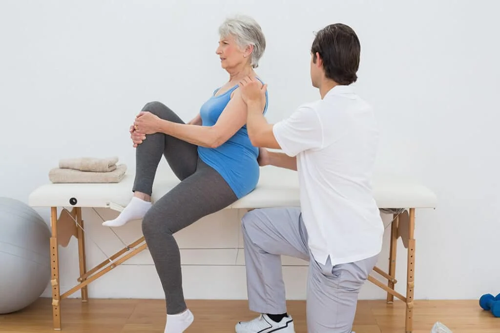 male-physiotherapist-examining-senior-womans-back